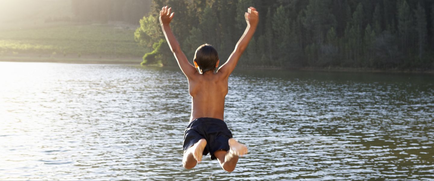 Boy jumping into water