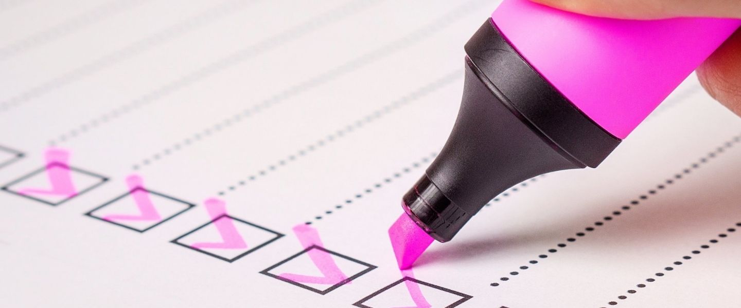 Pink pen making ticks on a checklist